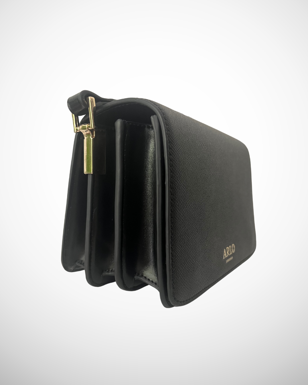 A black and gold vegan textured leather crossbody casual handbag for day use with adjustable strap. Minimal, quiet luxury, sophisticated, understated, simple design by ARLO London. Multiple organisation compartments with magnetic snap button closure