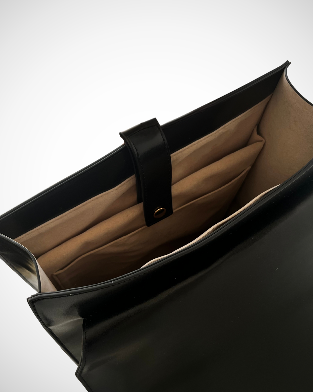 Smart and sophisticated black structured vegan leather backpack / rucksack for laptop with separate compartments including pen loops, zipped inner pocket, smooth patent cruelty-free material for work / office use. Quiet luxury, minimal, mid luxury affordable simple design. Adjustable straps for comfortable wear.