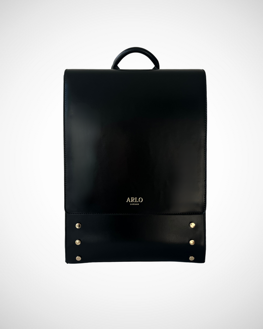 Smart and sophisticated black structured vegan leather backpack / rucksack for laptop with separate compartments including pen loops, zipped inner pocket, smooth patent cruelty-free material for work / office use. Quiet luxury, minimal, mid luxury affordable simple design. Adjustable straps for comfortable wear.