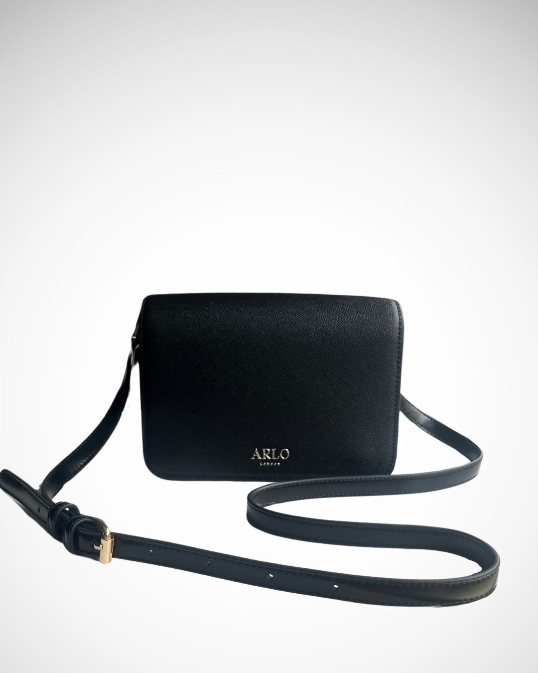 A black and gold vegan textured leather crossbody casual handbag for day use with adjustable strap. Minimal, quiet luxury, sophisticated, understated, simple design by ARLO London. Multiple organisation compartments with magnetic snap button closure.