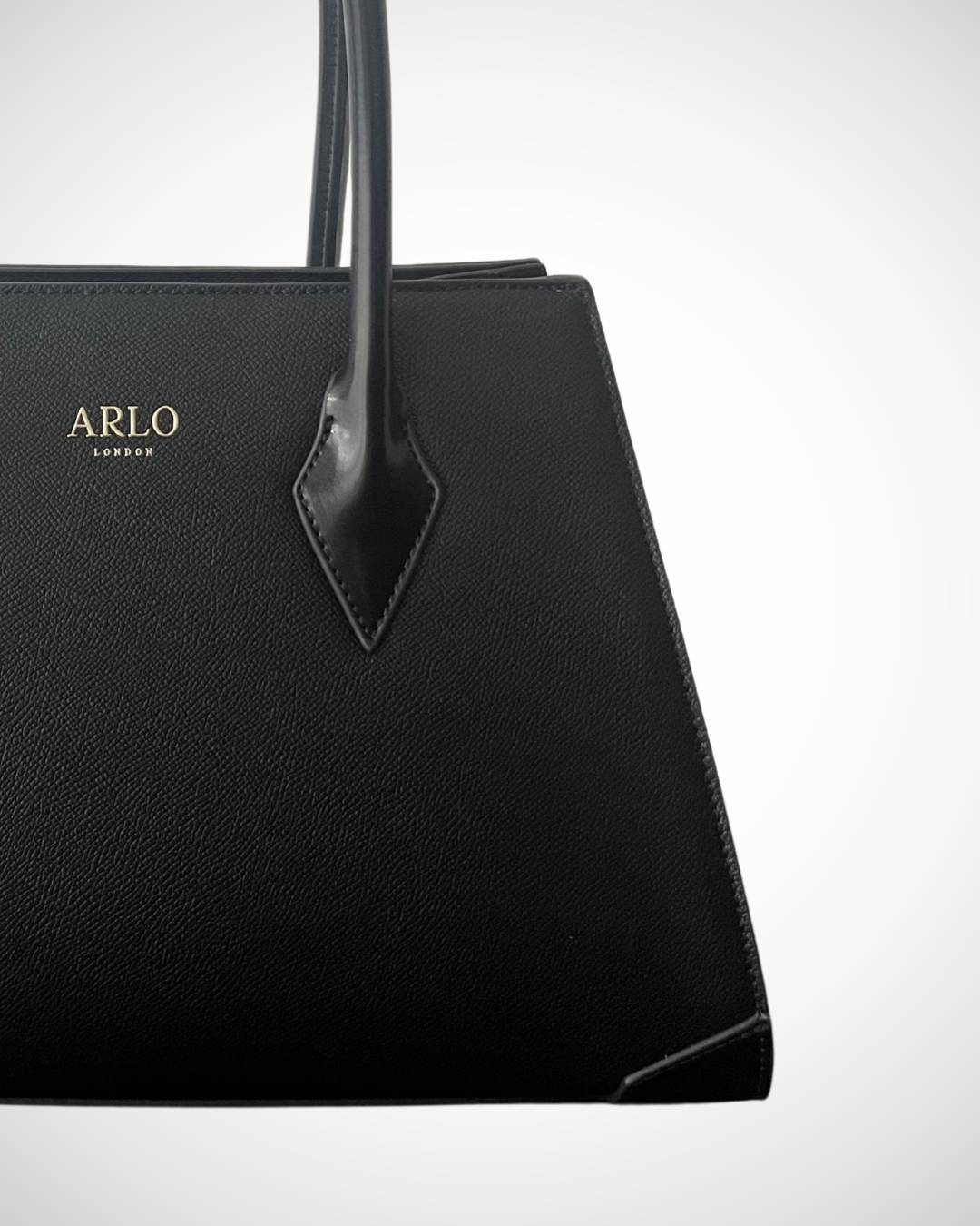 smart sophisticated black structured trapezium tote handbag for work made from vegan leather with separate compartments for organisation, long handles to wear on shoulder or on the arm, plain, office appropriate, spacious, mid luxury, quiet fashion