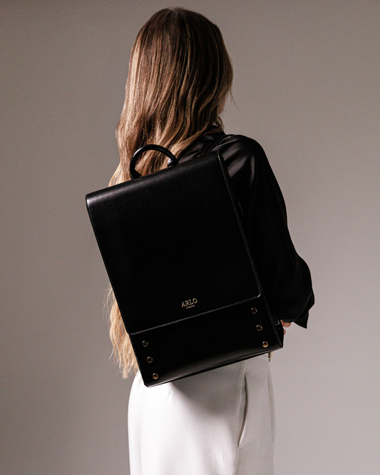 pretty professional woman with a smart black stylish backpack for work and wearing a smart office suit outfit. 