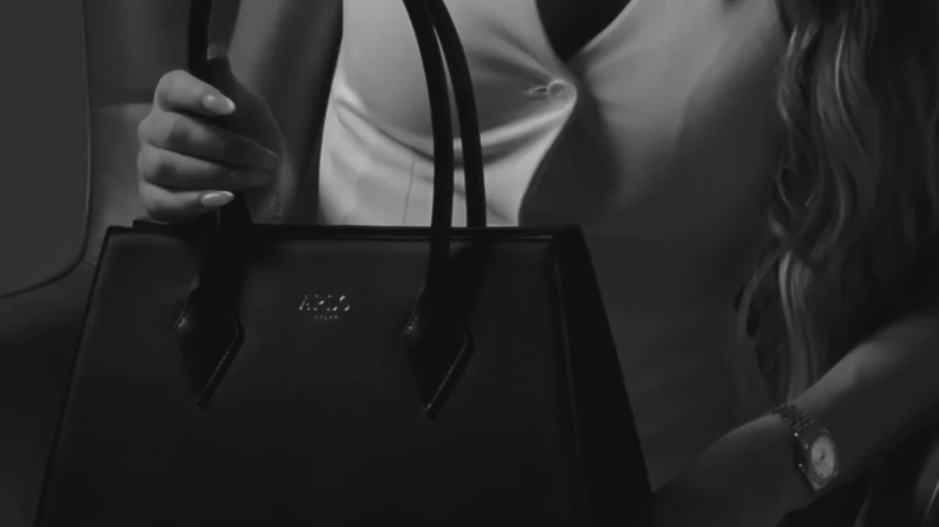 Load video: A collection of black structured work bags for professional women including a tote and a backpack suitable for laptop created by ARLO London